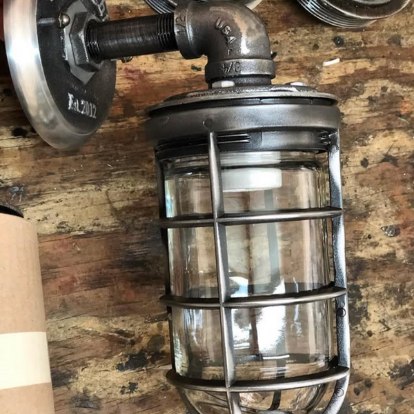 Vintage-style industrial wall sconce with aged metal look