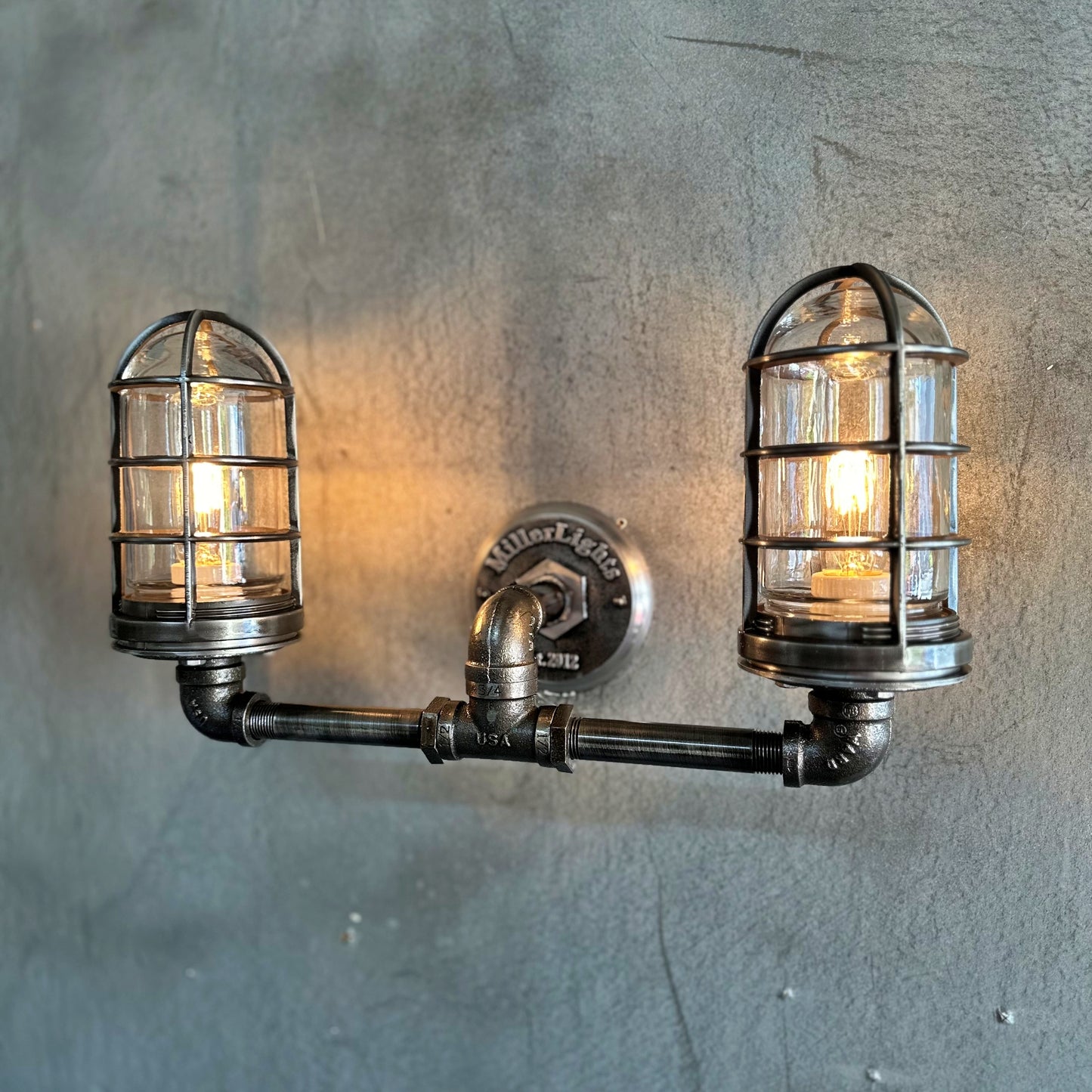 2 light wall sconce with cage and black piping 