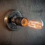 Rustic ceiling light with warm glowing Edison bulb.