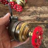 /2 inch industrial iron pipe lamp switch with a vintage red faucet handle on a raw metal finish.