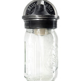 industrial sconce light, Instead of a traditional shade, the bulb is enclosed inside a clear glass mason jar, repurposed as the light cover. The jar has embossed markings and the classic “Ball” logo, adding vintage authenticity