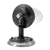 The mason jar is mounted on a wall with a sturdy, industrial-looking metal fixture