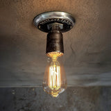 Industrial-style light with exposed filament bulb.
