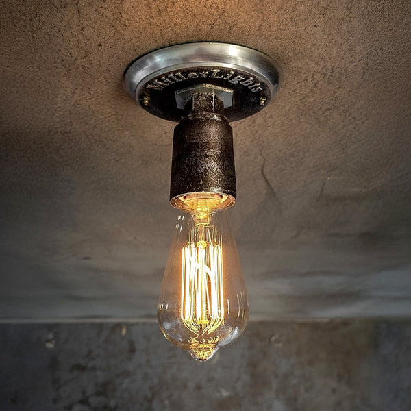 Industrial-style light with exposed filament bulb.