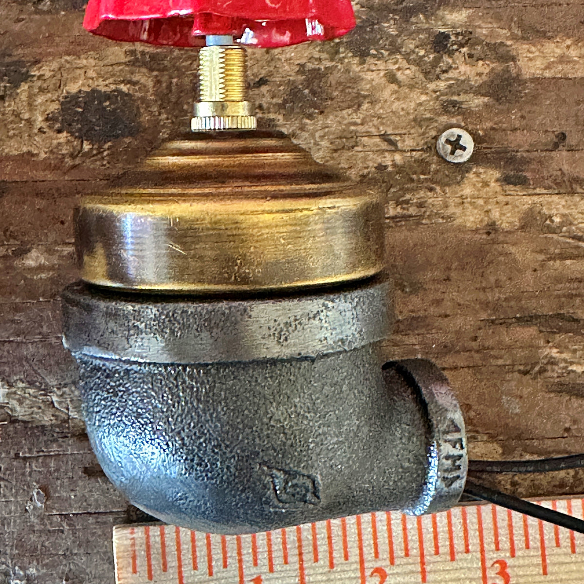 Metal valve with red handle for iron pipe.