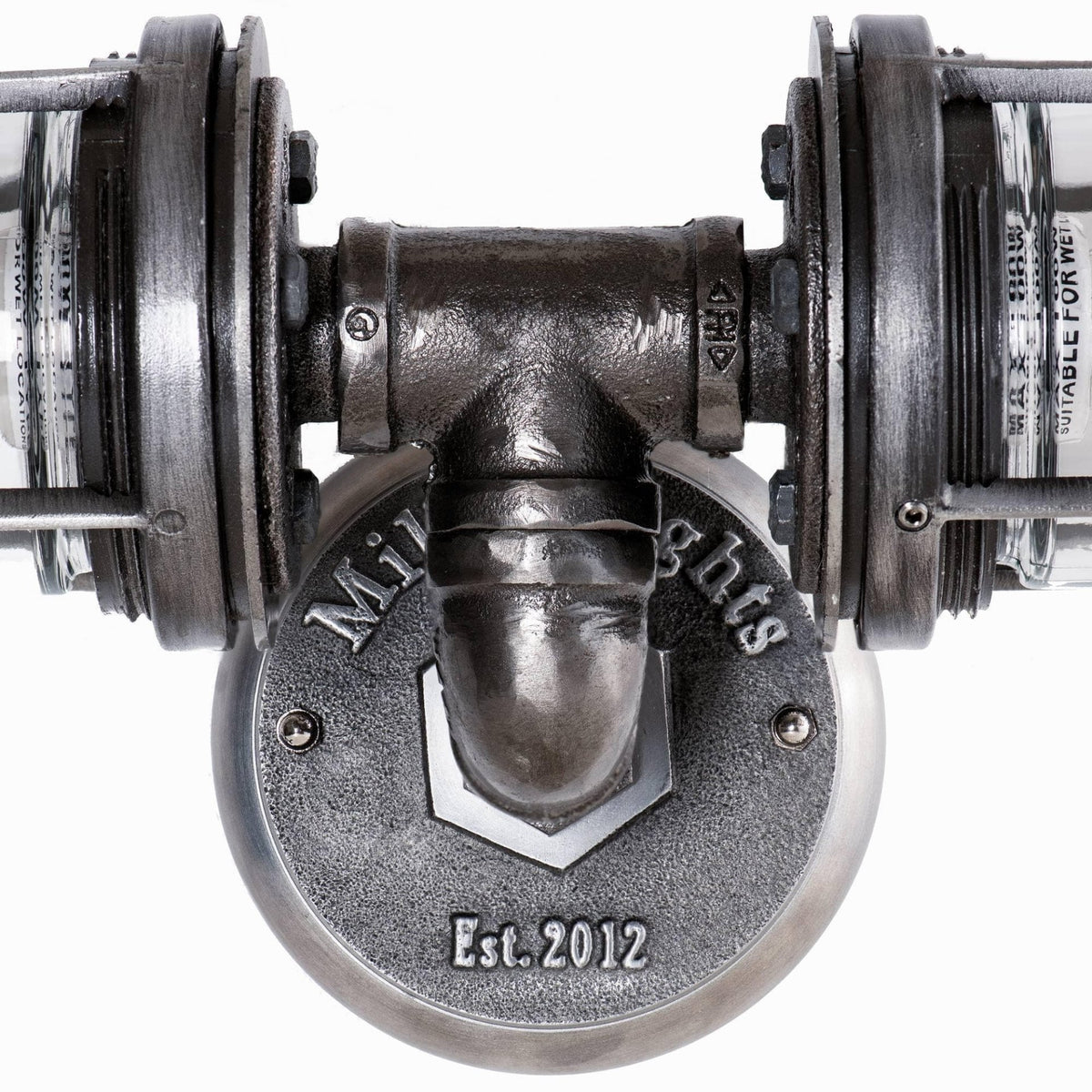 Close-up view of the MillerLights industrial vanity light fixture installed in an upside down position, showcasing the central iron pipe tee joint and the engraved brand wall plate.